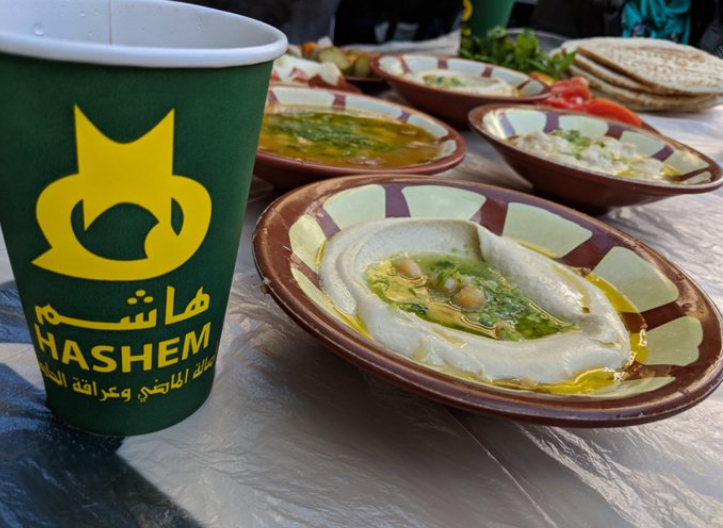 مطعم هاشم تقديم صحن حمص بزيت الزيتون مع خبز طازج في هاشم