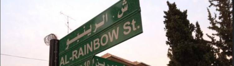 لافتة شارع الرينبو مع حركة الناس نهارًا