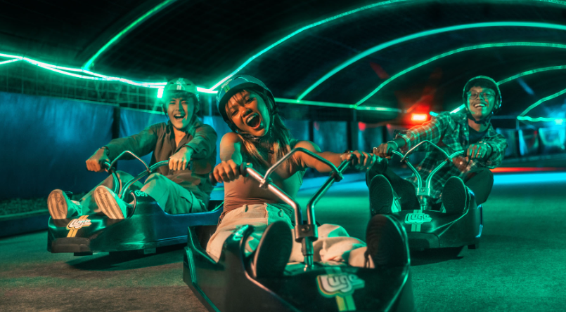 عربات لوج تنزل مسارًا منحدرًا بين الأشجار في Skyline Luge Sentosa