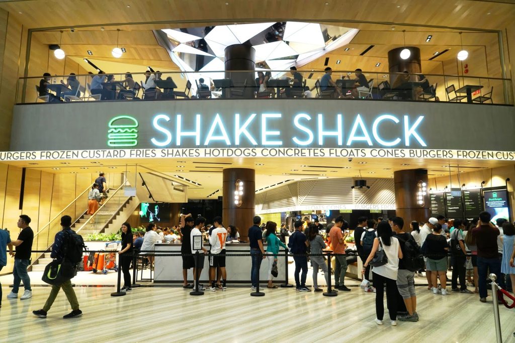 اجهة Shake Shack Jewel Changi مع إطلالة على قبة الزجاج و Rain Vortex.”